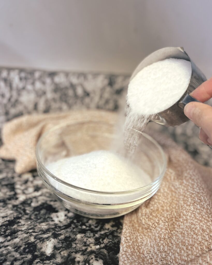 Epsom salts being poured into a glass bowl