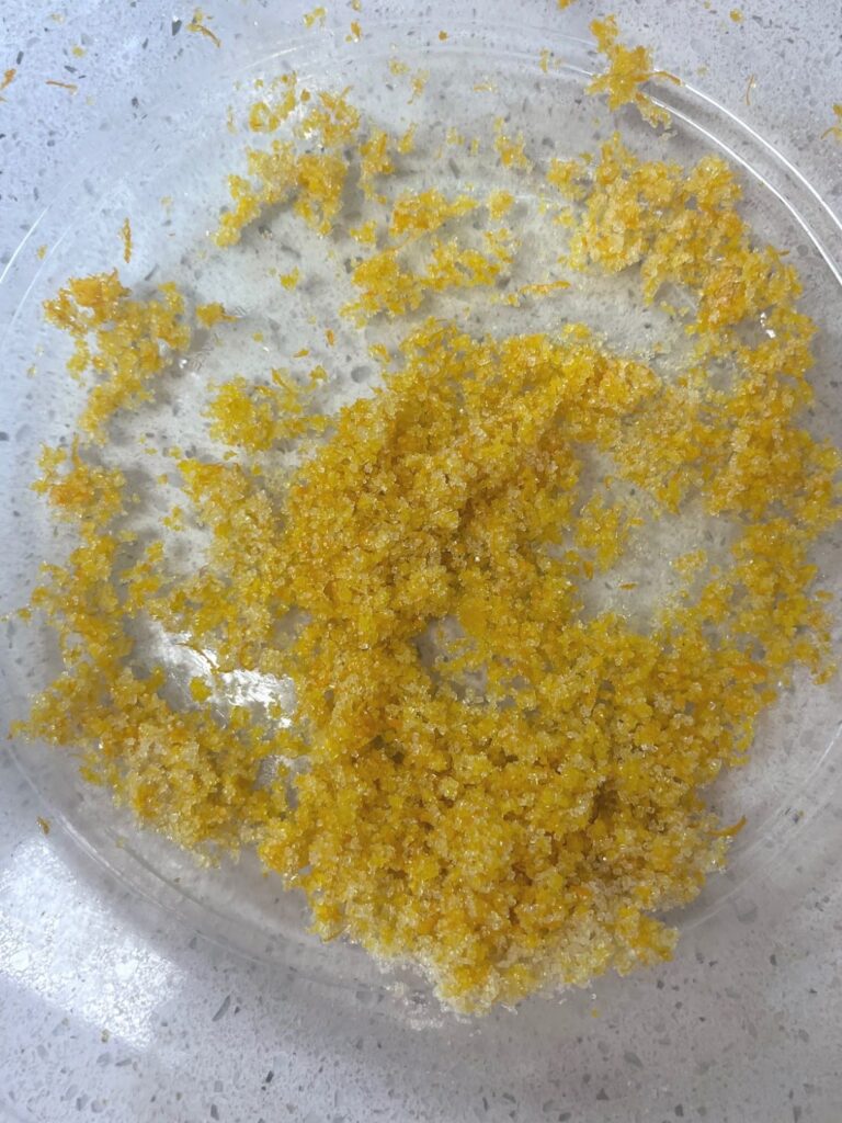 A large glass bowl with a little bit of orange zest and sugar.