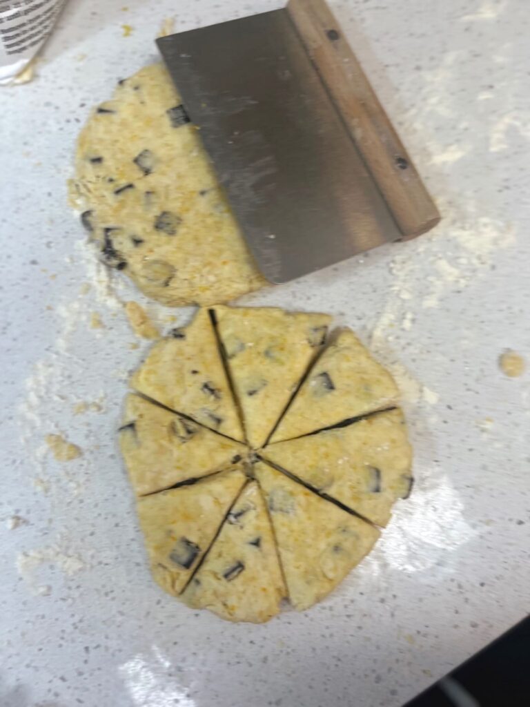Two disks of scone dough on a counter, one is divided into eight pieces.