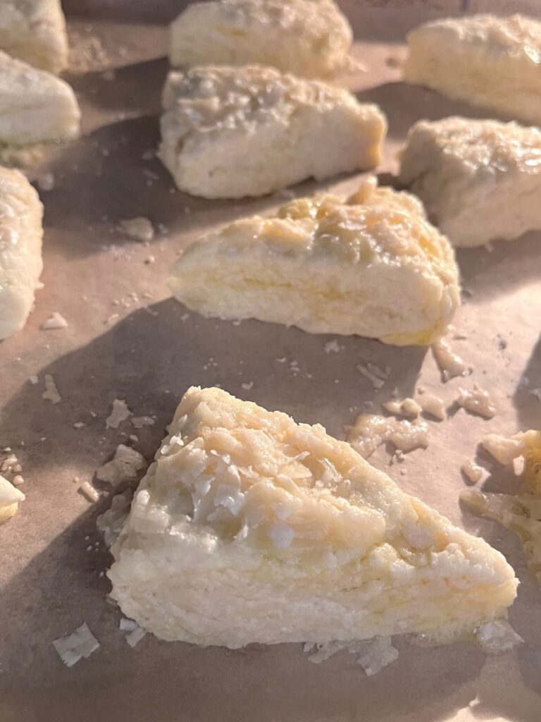 Triangles of scone dough on a sheet tray.