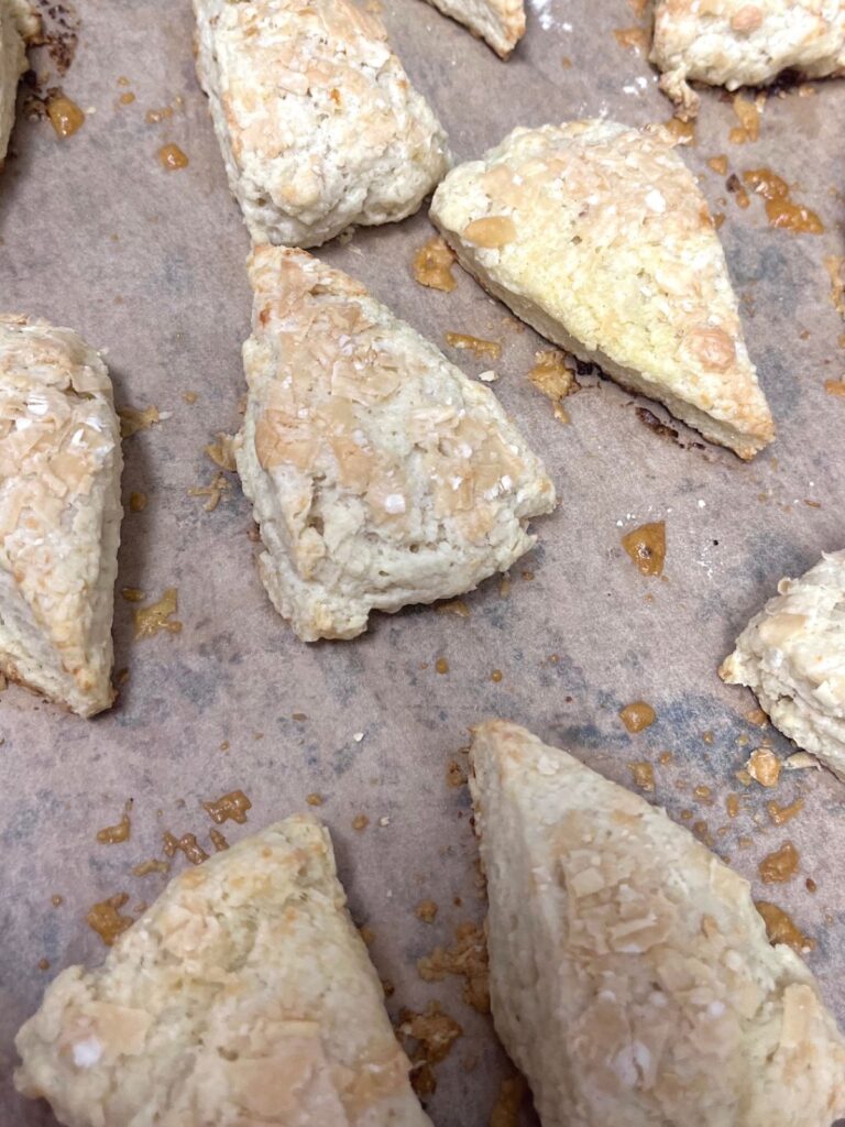 A tray of freshly baked sourdough scones with cheese browned on top.