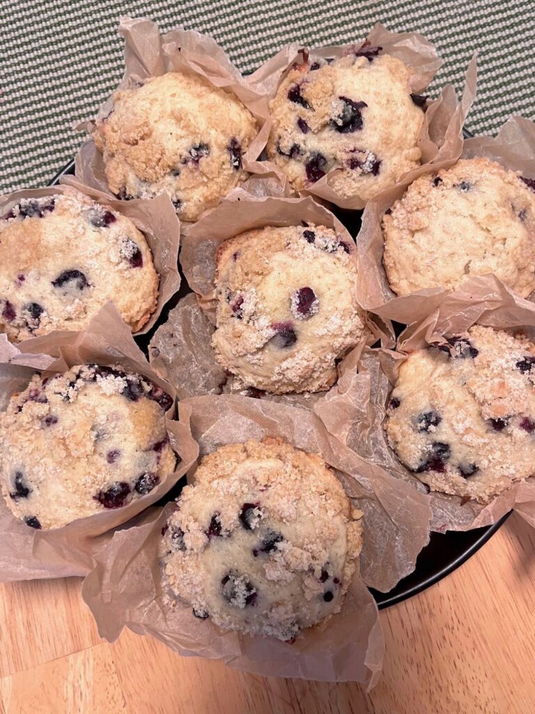 A large plate full of blueberry muffins.