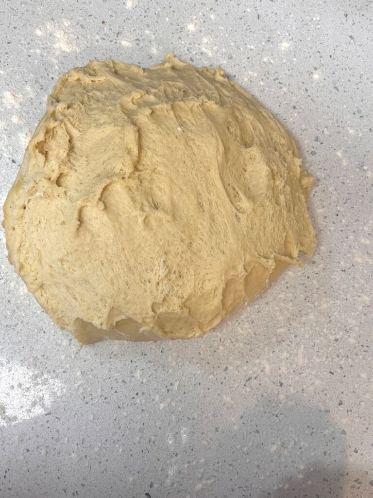 A ball of dough that is on a lightly floured counter.