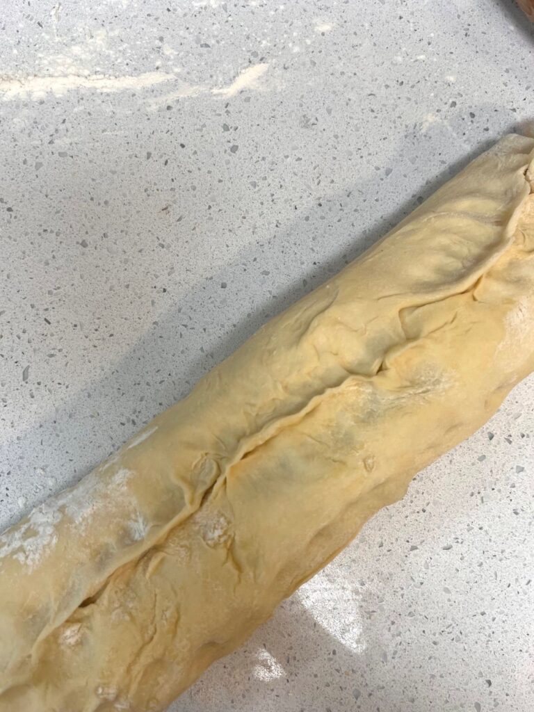 An uncut log of cinnamon rolls.