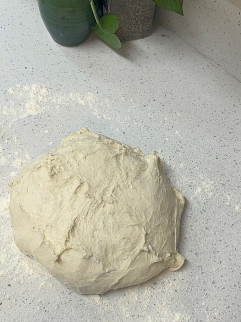 A ball of bread dough on a countertop.
