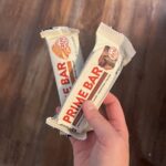 Two prime protein bars crossed over each other. One chocolate and the other peanut butter.