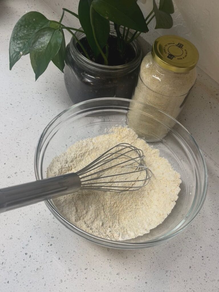 A bowl of dry ingredients with a whisk
