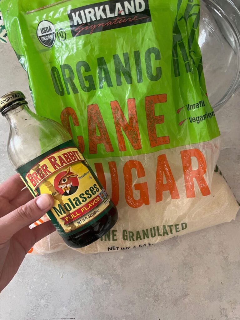 A bag of organic white sugar and a bottle of molasses.
