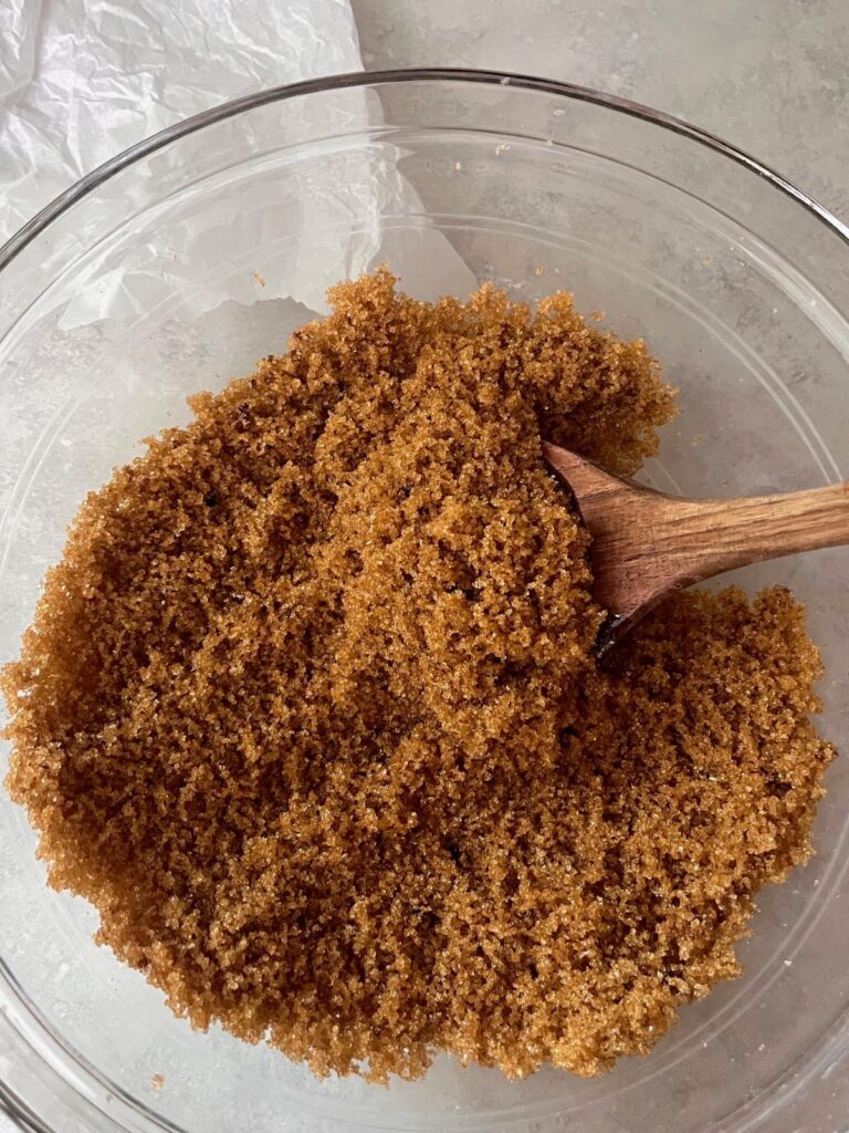 A bowl of homemade brown sugar with a wooden spoon.