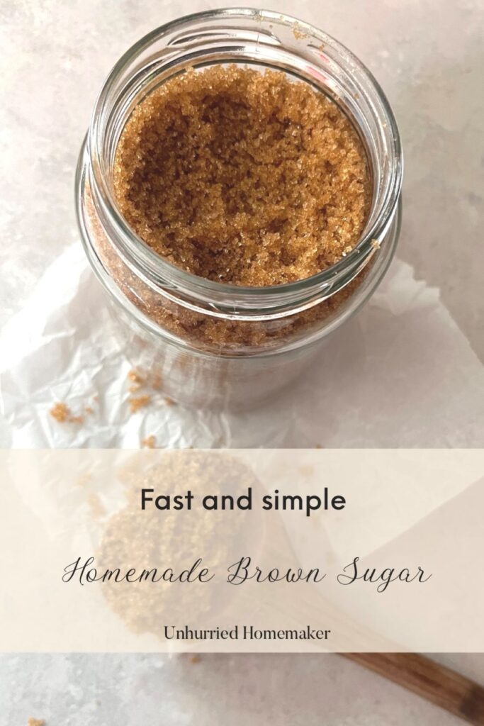 A jar full of homemade brown sugar on a crumpled piece of parchment paper.